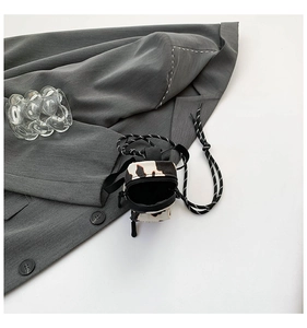 Detailed close-up of a mini cow-print crossbody bag with a zipper and fine rope strap