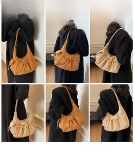 Detail view of retro suede tote bag featuring pleated stitching and side pocket