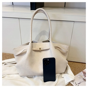 Dettaglio della borsa tote crema con chiusura in metallo e telefono per scala taglia
