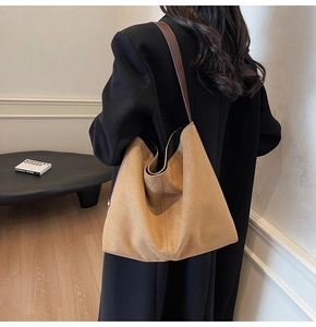 Detail of minimalist brown faux suede bucket bag showing fine matte texture and strap
