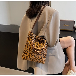 Borsa tote leopardata chic con manici in bambù indossata da una modella