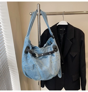 Detail der hellblauen Jeans-Einkaufstasche mit funktionellen Taschen und Lederschnallen