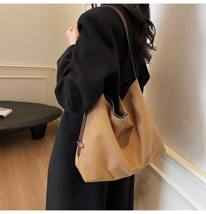 Detail of camel suede tote bag with soft hobo silhouette and brown leather straps