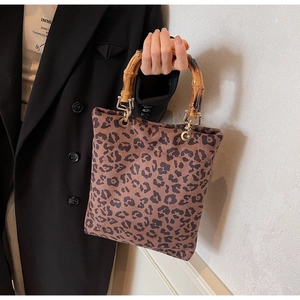 Dettaglio borsa shopper leopardata con manico in bambù e finiture in metallo dorato