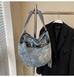 Detailansicht der Vintage-Jeans-Tasche mit Metallnieten und schwarzen Lederriemen