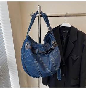 Detailansicht der blauen Denim-Umhängetasche mit Ziernähten und braunen Lederriemen