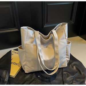 Vue détaillée du grand sac cabas beige avec poche avant profonde et poches latérales