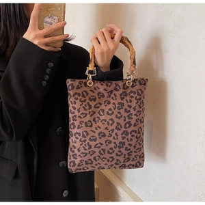 Dettaglio della borsa tote leopardata con manico in bambù naturale e anelli in metallo dorato