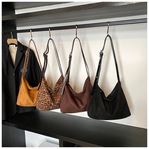 Selection of matte PU leather tote bags in mustard, leopard, coffee, and black on a rack
