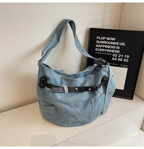 Detailansicht der Jeans-Umhängetasche mit Multi-Taschen-Design und schwarzem Leder-Zierriemen