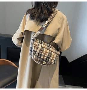 Detail view of the retro plaid pattern and golden metal twist lock on a shoulder bag