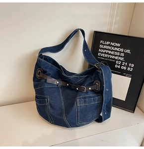 Detailansicht der dunkelblauen Denim-Tasche mit Kontrastnähten und Metallschnallendetail