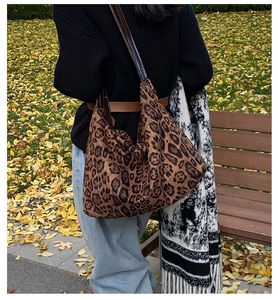 Close-up of leopard print large tote bag with fabric texture on an autumn park bench