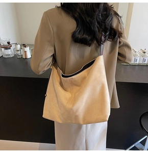 Close-up of matte khaki suede hobo bag with dark brown leather shoulder strap detail