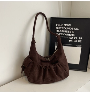 Detail view of coffee brown suede tote bag featuring front pleated pocket and dual metal zippers
