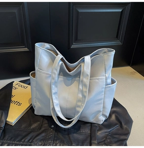 Vue détaillée du sac fourre-tout en nylon bleu brume avec poches et bandoulières