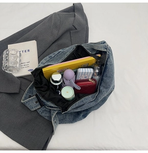 Detailansicht des geräumigen Denim-Shoppers von innen mit Mappen, Schirm und Geldbörse