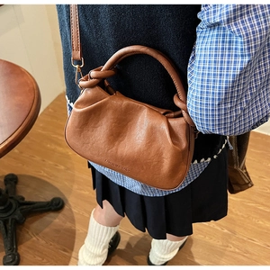 Vue détaillée du sac bandoulière plissé marron avec poignée nouée et boucle en métal