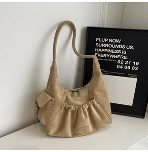 Detail shot of the suede hobo bag with zip closure and elegant side pocket detail