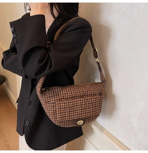 Detail of vintage wool plaid shoulder bag featuring a metal twist lock and wide strap