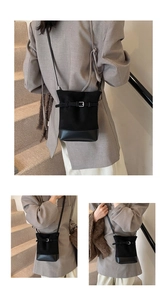 Détail du sac seau vintage noir avec finition mate et ceinture à boucle métallique