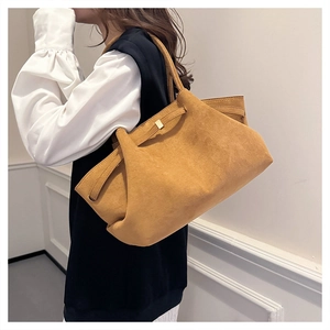 Dettaglio della borsa tote in pelle scamosciata gialla con struttura a pieghe e fibbia