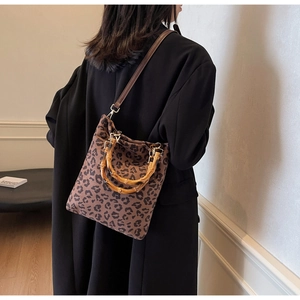 Dettaglio della borsa leopardata vintage con manici in bambù e tracolla in pelle regolabile