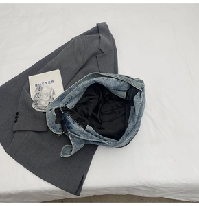 Draufsicht auf große gewaschene Denim-Tragetasche mit geräumigem Innenraum und Gurt