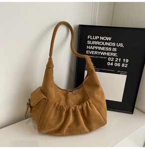 Detail of a brown suede Hobo tote bag featuring pleated design and zip closure