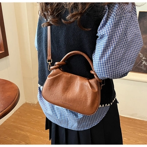 Dettaglio della borsa a nuvola marrone vintage con fibbie in metallo e logo