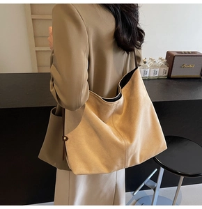 Detail view of the soft suede texture and spacious interior of the beige hobo bucket bag