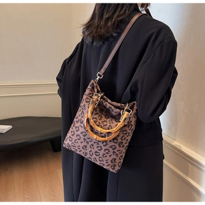 Dettaglio della borsa tote leopardata con manici in bambù e tracolla in ecopelle