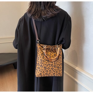 Dettaglio borsa leopardata con manico vintage in bambù e tracolla marrone scuro