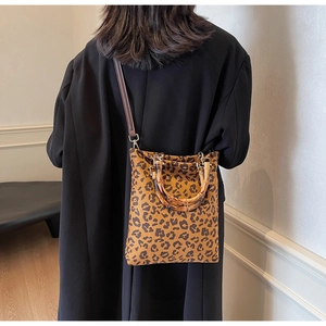 Dettaglio della borsa tote vintage leopardata con manici in bambù e tracolla in pelle scura