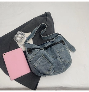 Details zur Vintage Washed Blue Denim Textur und Multi-Pocket Design mit Lederriemen