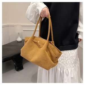 Dettaglio della borsa tote in pelle scamosciata marrone con lacci laterali dorati