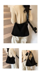 Close-up of black suede tote bag with adjustable wide shoulder strap and hobo style