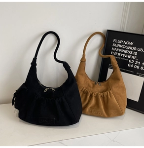 Detail showing black and tan suede hobo bags with pleated texture and MKMX logo