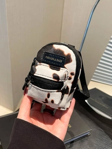 Mini cow print crossbody bag for kids featuring a stylish black and white pattern
