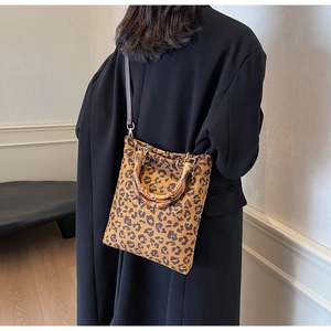 Dettaglio della borsa leopardata con manico in bambù e tracolla in pelle marrone