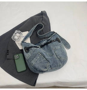 Detail des verstellbaren Lederriemens und der Silberschnalle an der Denim-Tasche