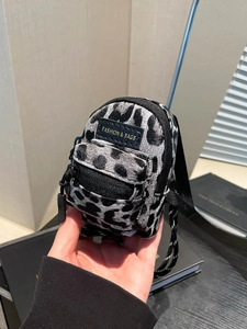 Mini girls leopard print crossbody bag with fashion label and zipper detail in hand