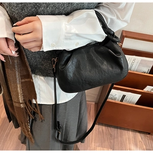 Dettaglio borsa a nuvola nera a pieghe con tracolla regolabile e goffratura di moda