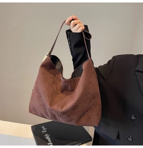 Detail of soft suede texture and gold hardware on large brown hobo shoulder bag