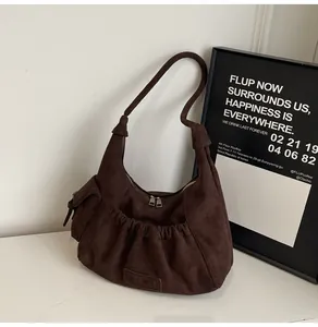 Detail of dark brown suede tote bag with ruched pocket and dual metal zippers