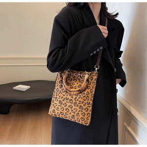 Dettaglio della borsa tote leopardata con manico in bambù e tracolla rimovibile inclusa