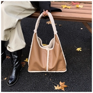 Dettaglio del bordo in montone sintetico su borsa hobo in pelle marrone con foglie
