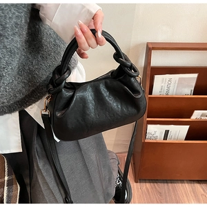 Dettaglio borsa a nuvola nera con catena a grandi anelli e trama in pelle vintage