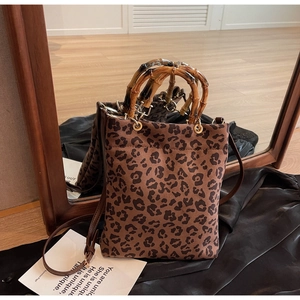 Dettaglio della borsa tote leopardata con manici in bambù naturale e tracolla in pelle
