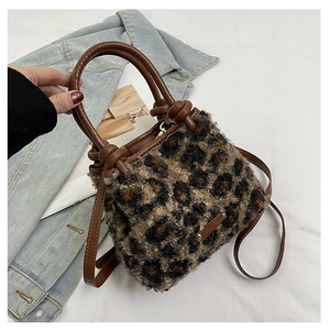 Dettaglio della borsa a secchiello leopardata con manici in pelle e placchetta in metallo